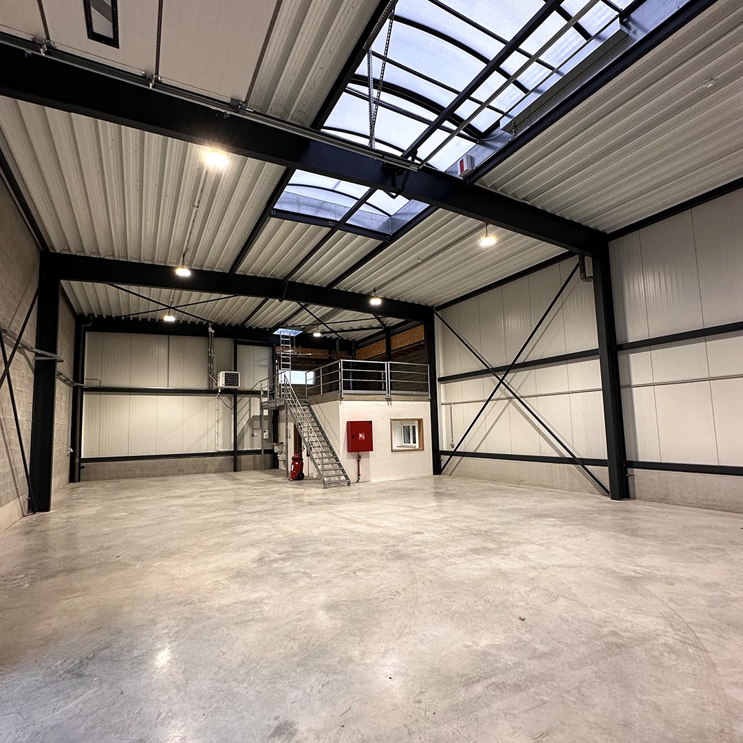 Large industrial warehouse with metal beams and skylights